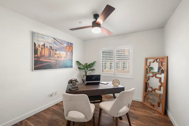 a view of a sign board with flower plants and wooden fence
