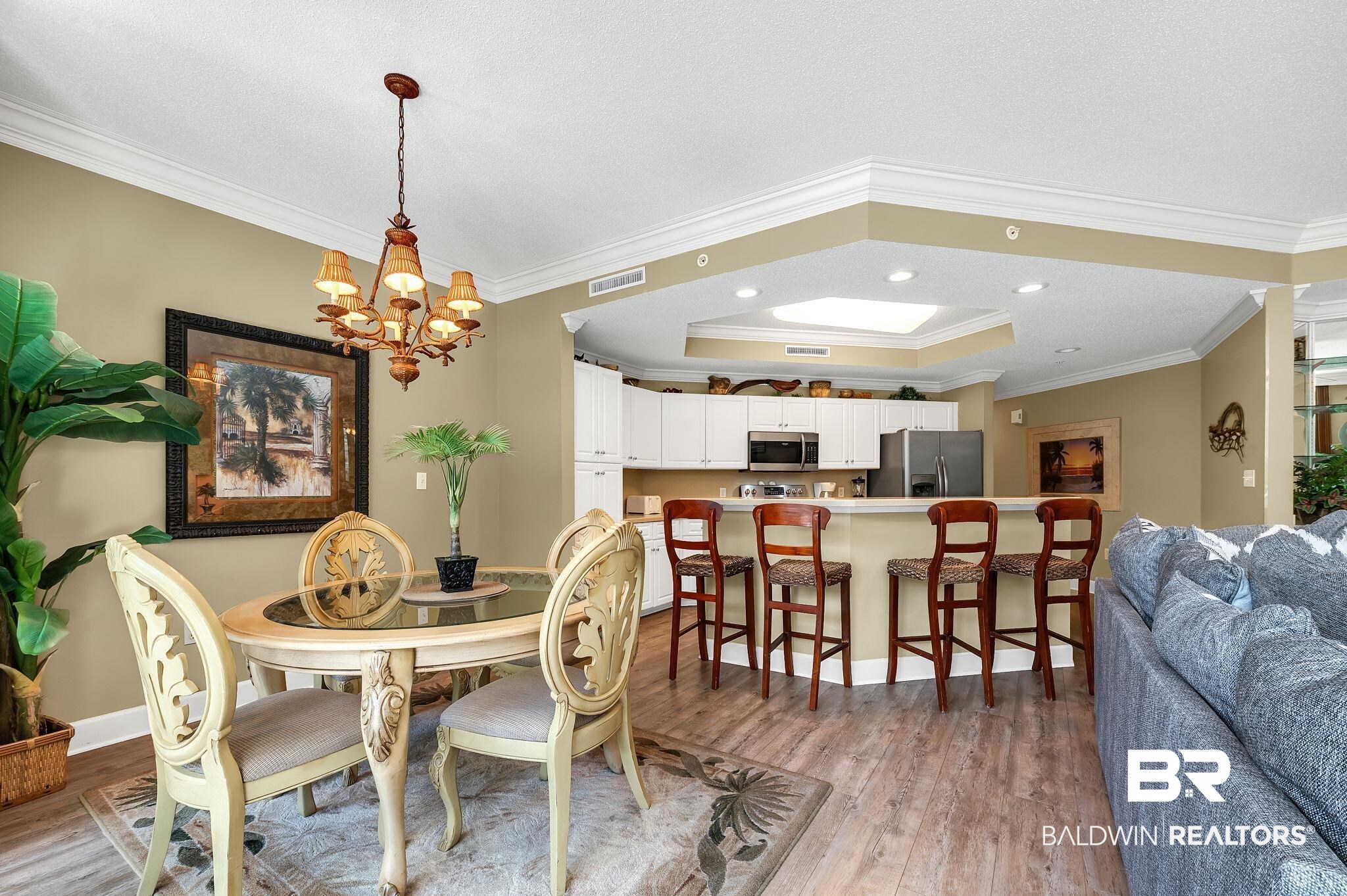27580 Canal Road, Unit 1214 AND BOAT SLIP #62 Orange Beach, AL 36561 - Photo 16 of 67 Dining room featuring light wood finished floors, a notable chandelier, visible vents, and ornamental molding