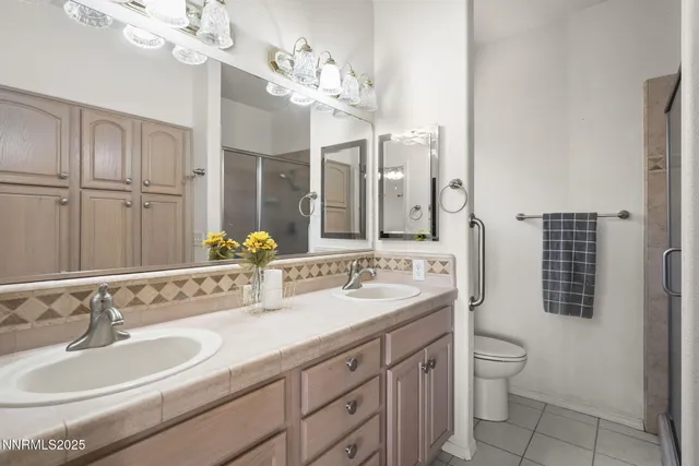 a bathroom with a double vanity sink mirror and toilet