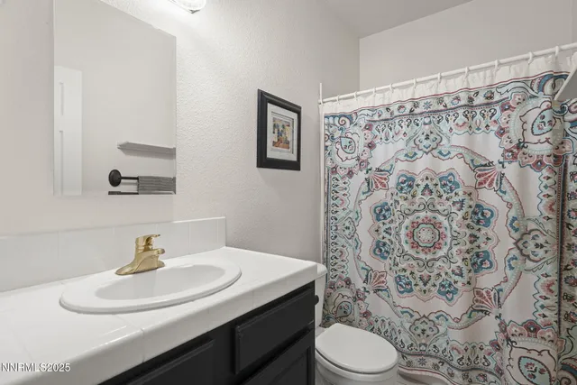 a bathroom with a sink toilet and a mirror