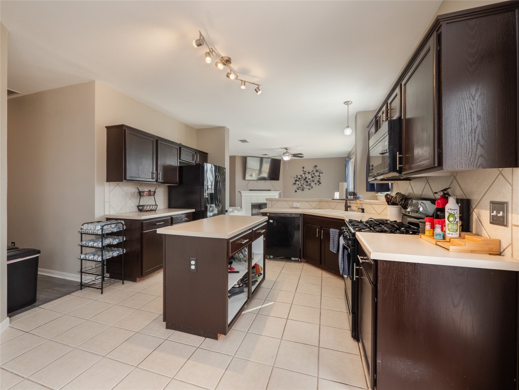 1819 Rutherford Drive Leander, TX 78641 - Photo 11 of 36 a kitchen with stainless steel appliances granite countertop a stove top oven a sink dishwasher and a refrigerator