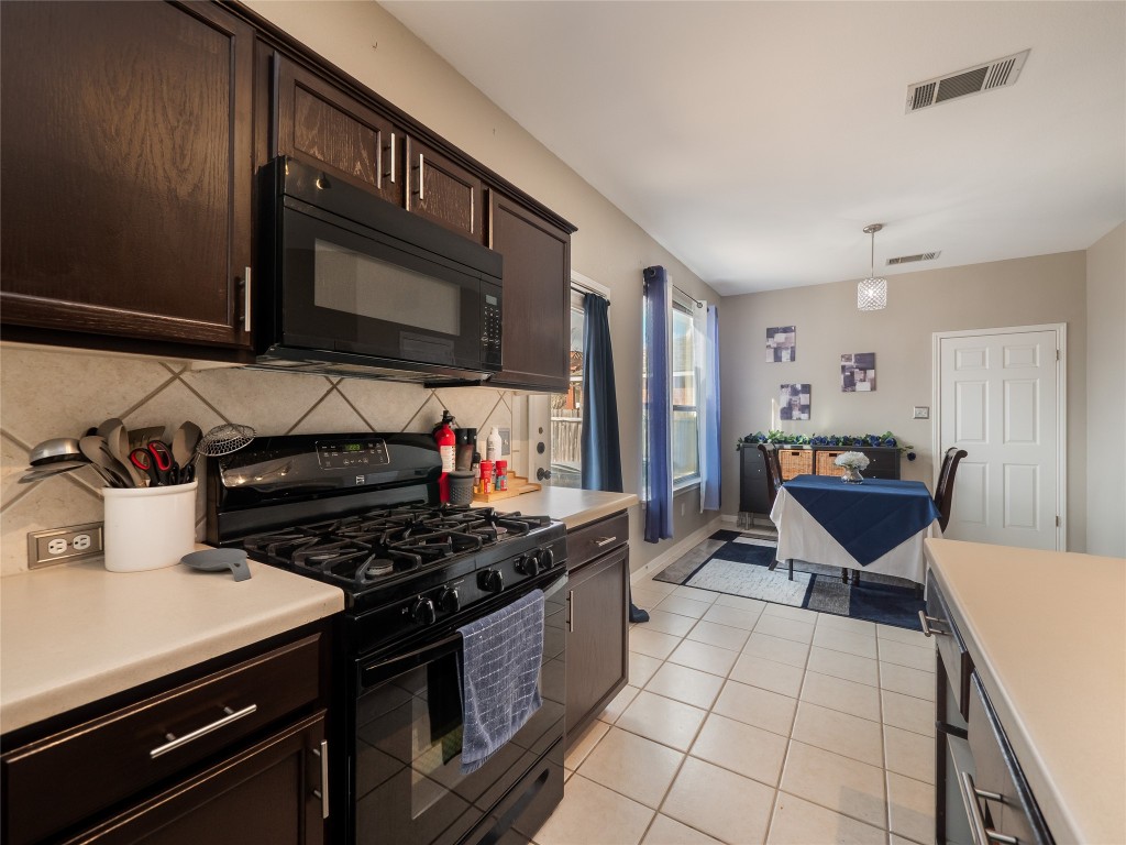 1819 Rutherford Drive Leander, TX 78641 - Photo 13 of 36 a kitchen with stainless steel appliances a stove a sink and a microwave