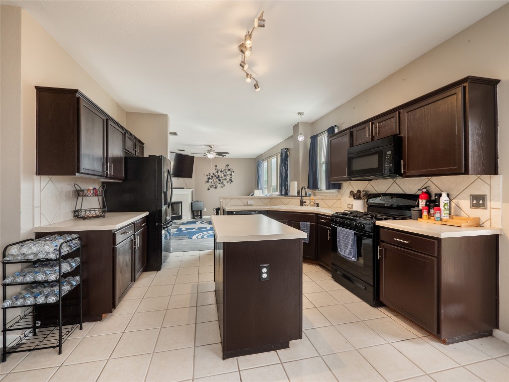 1819 Rutherford Drive Leander, TX 78641 - Photo 10 of 36 a kitchen with kitchen island granite countertop a sink counter top space appliances and cabinets