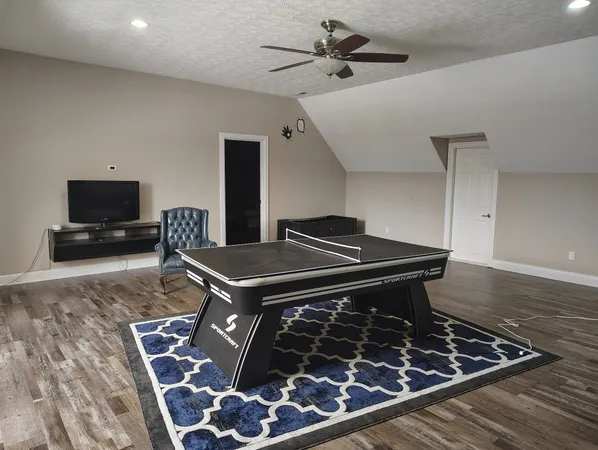 a living room with a stove kitchen view and a fireplace