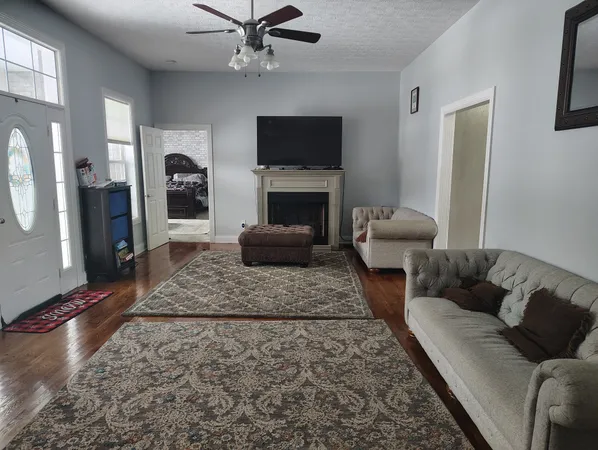 a living room with furniture a flat screen tv and a fireplace