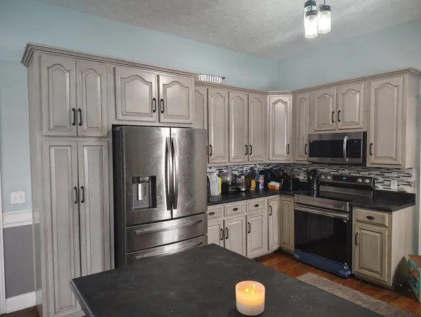 a kitchen with granite countertop a refrigerator stove and sink