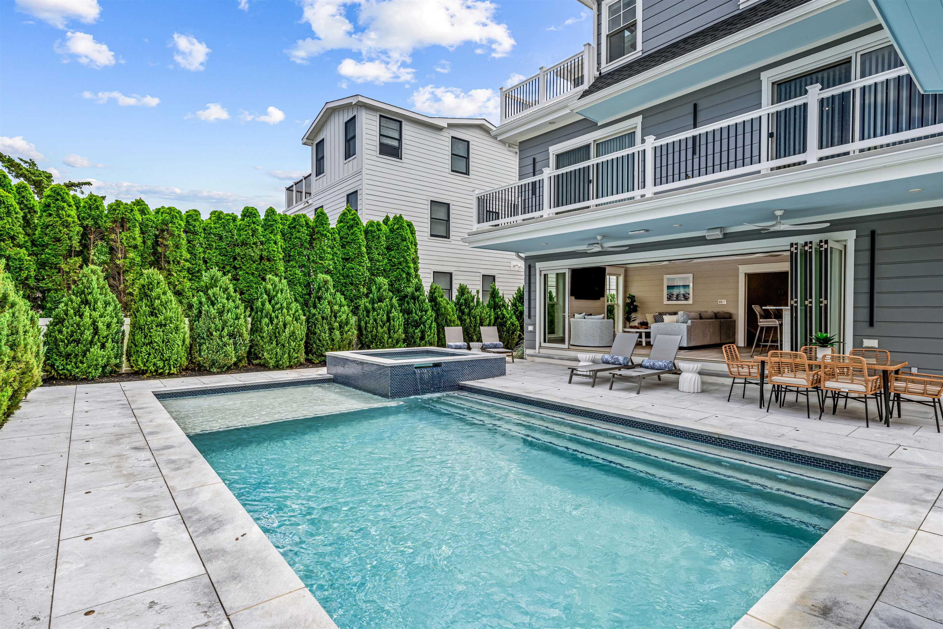 151 37th Street Avalon, NJ 08202 - Photo 20 of 50 a view of a patio with table and chairs potted plants and large tree