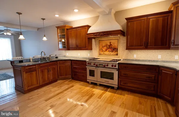 a kitchen with stainless steel appliances granite countertop a stove a sink and a microwave