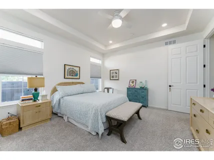 a spacious bedroom with a bed and a dresser in it