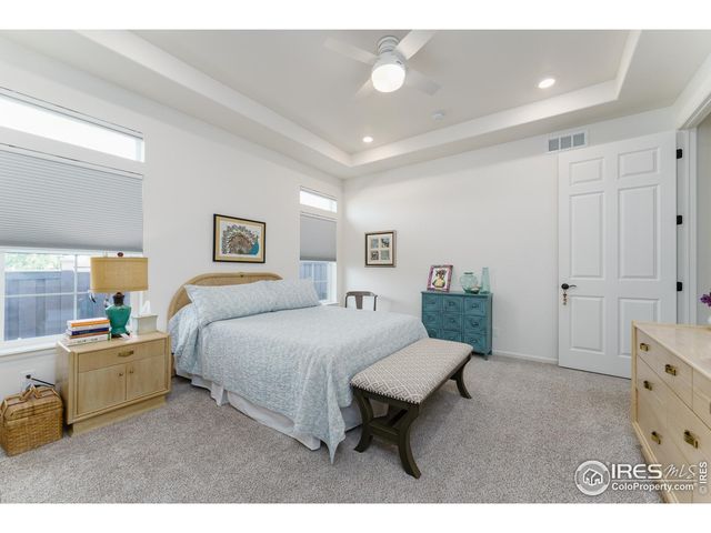 a spacious bedroom with a bed and a dresser in it