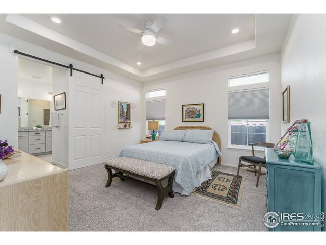 a spacious bedroom with a bed a couch and a view of living room