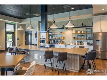 a kitchen with stainless steel appliances kitchen island granite countertop a table and chairs in it