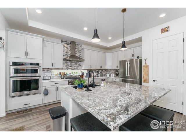 a kitchen with stainless steel appliances kitchen island granite countertop a stove refrigerator and microwave