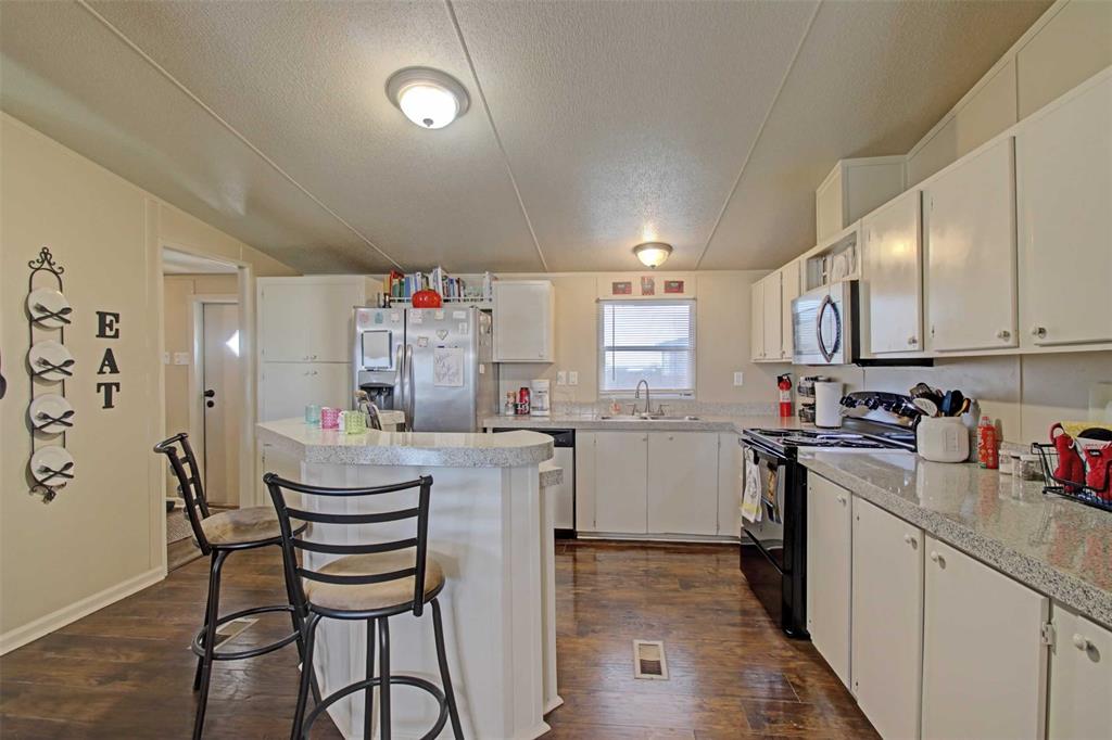 2004 Fall Creek Road Cleburne, TX 76033 - Photo 6 of 18 a kitchen that has a lot of cabinets in it and appliances