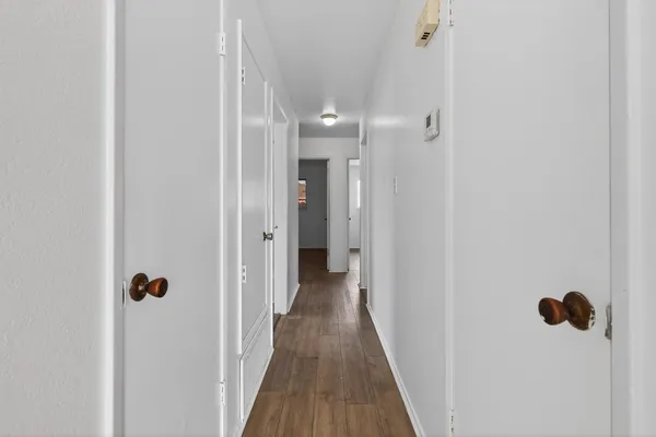 a view of a hallway with wooden floor
