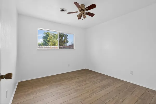 a view of a big room with wooden floor and a ceiling fan