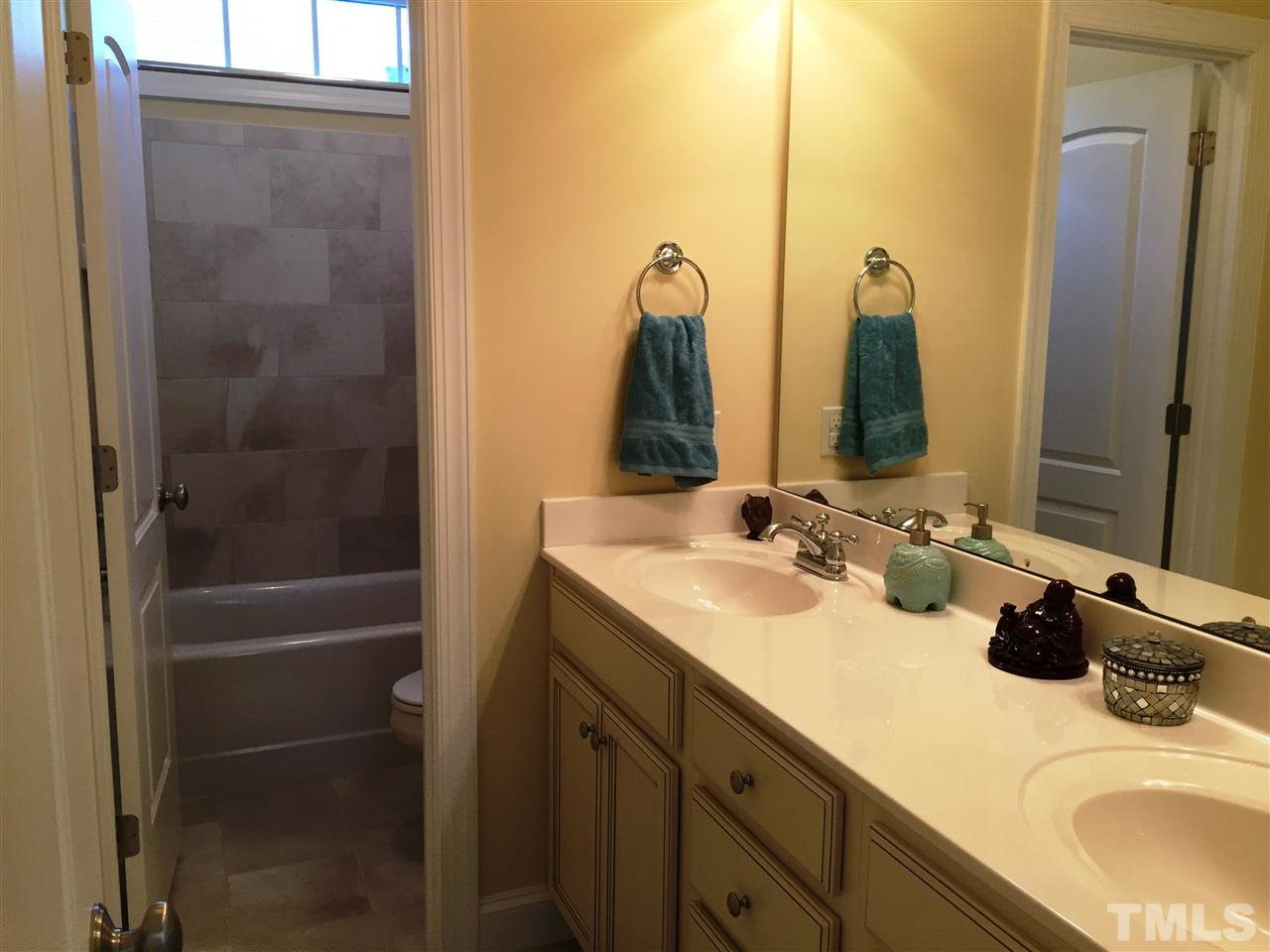1307 Ileagnes Road Raleigh, NC 27603 - Photo 22 of 24 The upstairs bathroom features a double raised height vanity and tile floors. The tiled tub/shower features a transom window above. The lavatory and tub/shower are in a separate room. Bathroom