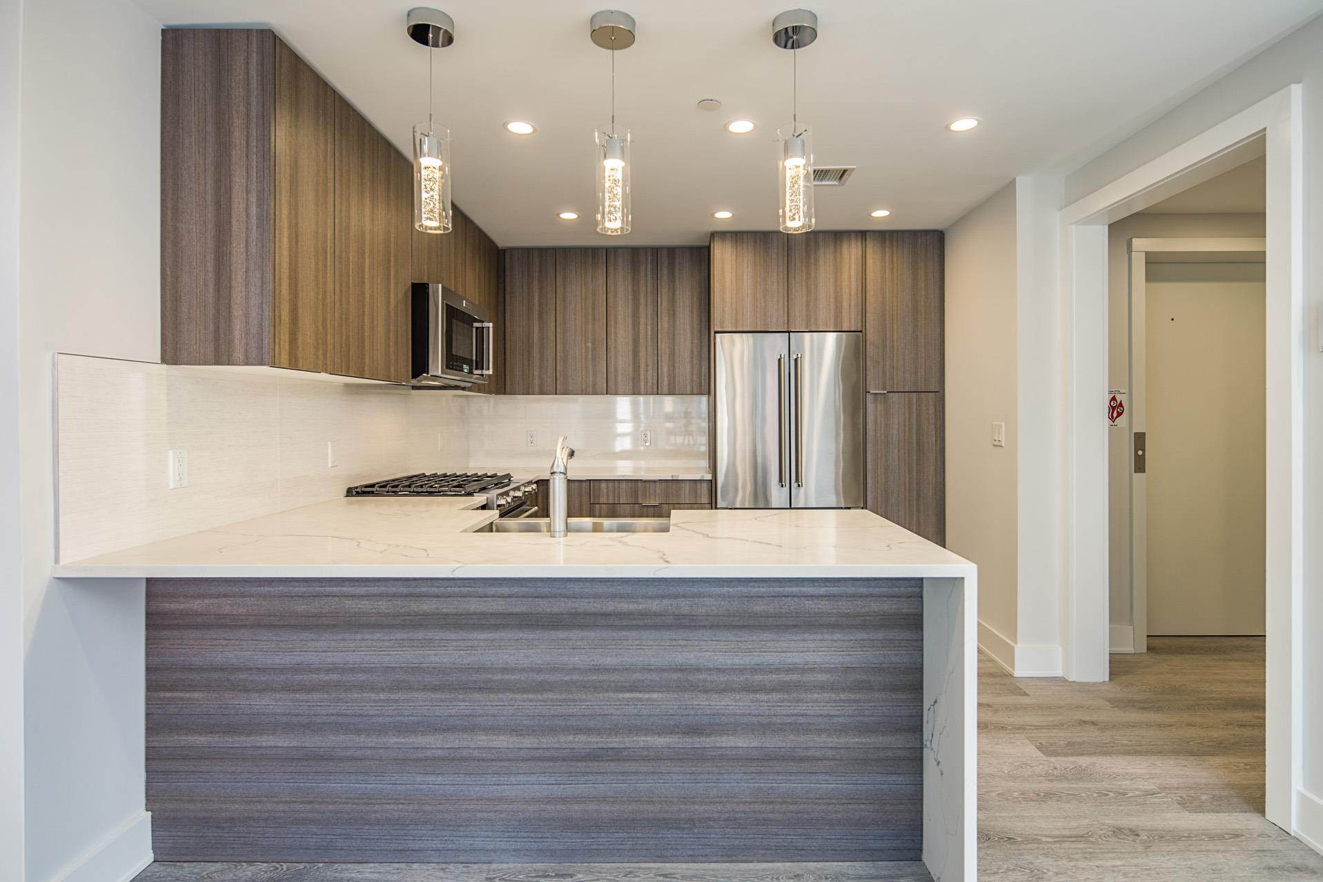 527 Monroe Street, Unit 3R Hoboken, NJ 07030 - Photo 4 of 22 a view of a kitchen with kitchen island a sink stainless steel appliances and cabinets