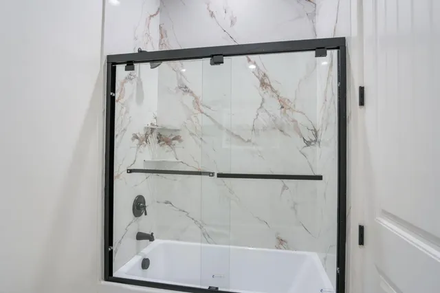 a bathroom with a double vanity sink a toilet and shower