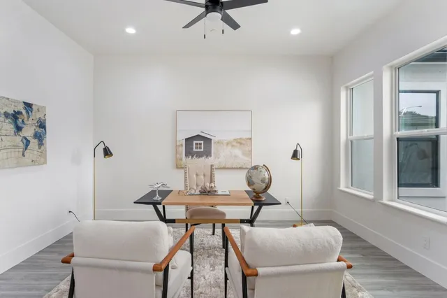 a living room with furniture wooden floor dining table and a fireplace