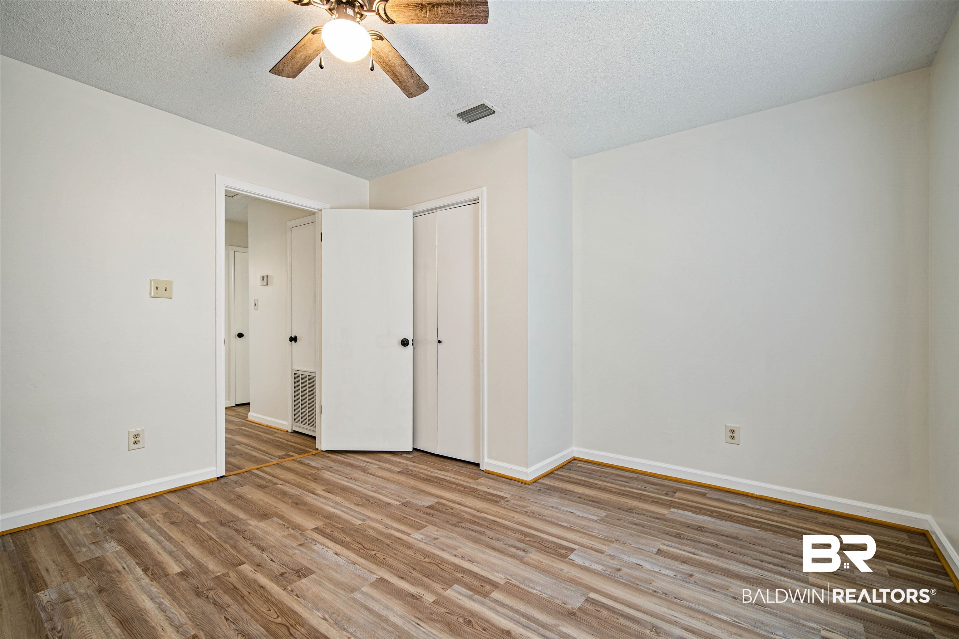 6701 Howells Ferry Road Mobile, AL 36618 - Photo 18 of 25 Unfurnished bedroom featuring a textured ceiling, light hardwood / wood-style flooring, a closet, and ceiling fan