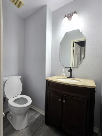 a bathroom with a toilet a sink and mirror