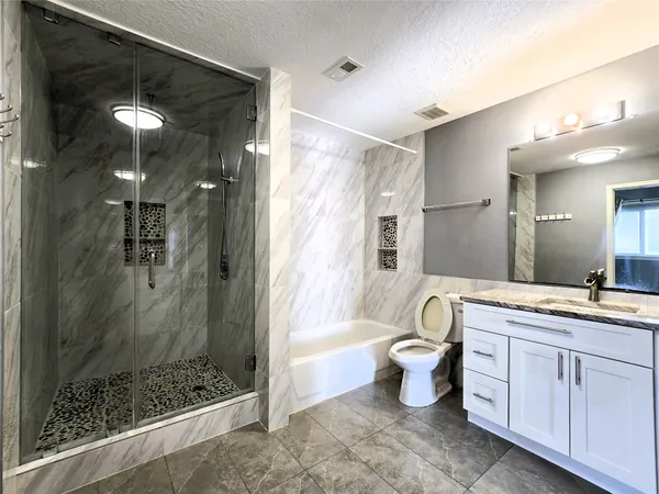 a bathroom with a double vanity sink toilet and shower