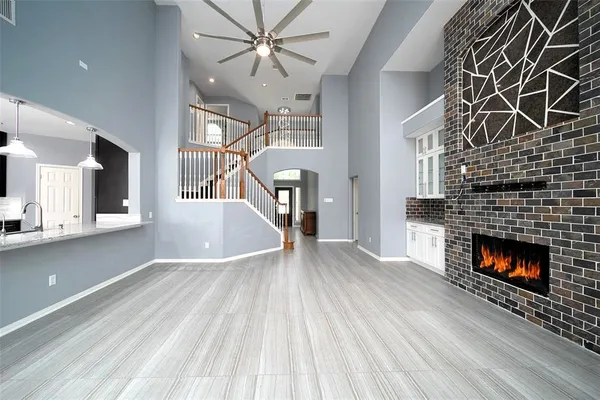 a view of an empty room with wooden floor fireplace and a window