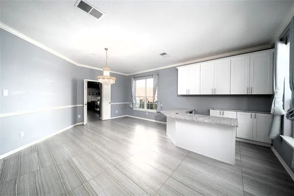 a large kitchen with cabinets wooden floor and stainless steel appliances