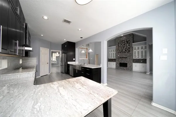 a large kitchen with kitchen island a sink stainless steel appliances and cabinets