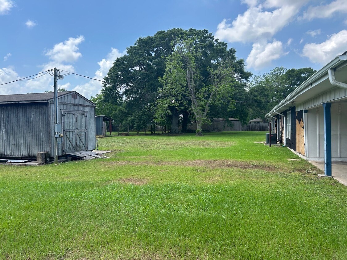 1420 South 29th Street Nederland, TX 77627 - Photo 6 of 19 a view of a backyard with potted plants and large tree
