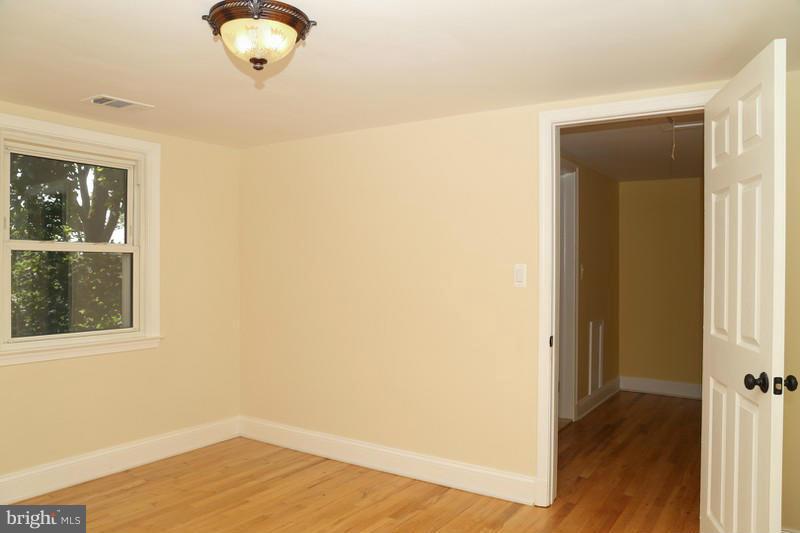 2429 Baldwin Mill Road Baldwin, MD 21013 - Photo 26 of 30 an empty room with wooden floor and windows