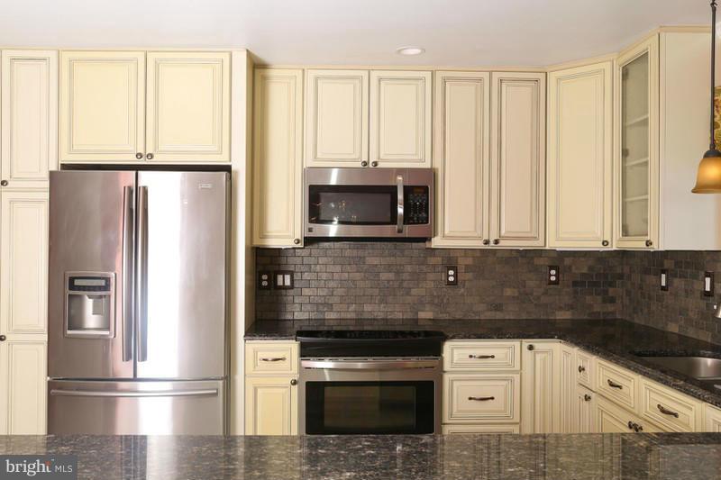 2429 Baldwin Mill Road Baldwin, MD 21013 - Photo 5 of 30 a kitchen with granite countertop white cabinets and stainless steel appliances
