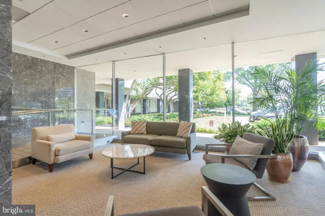 a living room with furniture and a floor to ceiling window