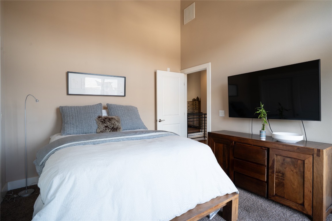 8110 Ranch Road 2222, Unit 45 Austin, TX 78730 - Photo 18 of 38 a bedroom with a bed and a flat screen tv