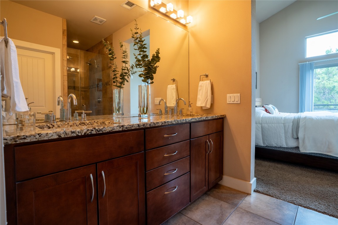 8110 Ranch Road 2222, Unit 45 Austin, TX 78730 - Photo 28 of 38 a en suite bathroom with a sink and a mirror