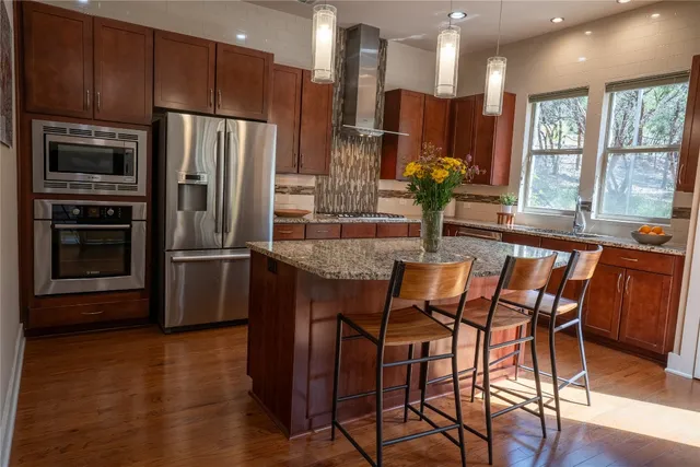a living room with wooden floor furniture and a ceiling fan