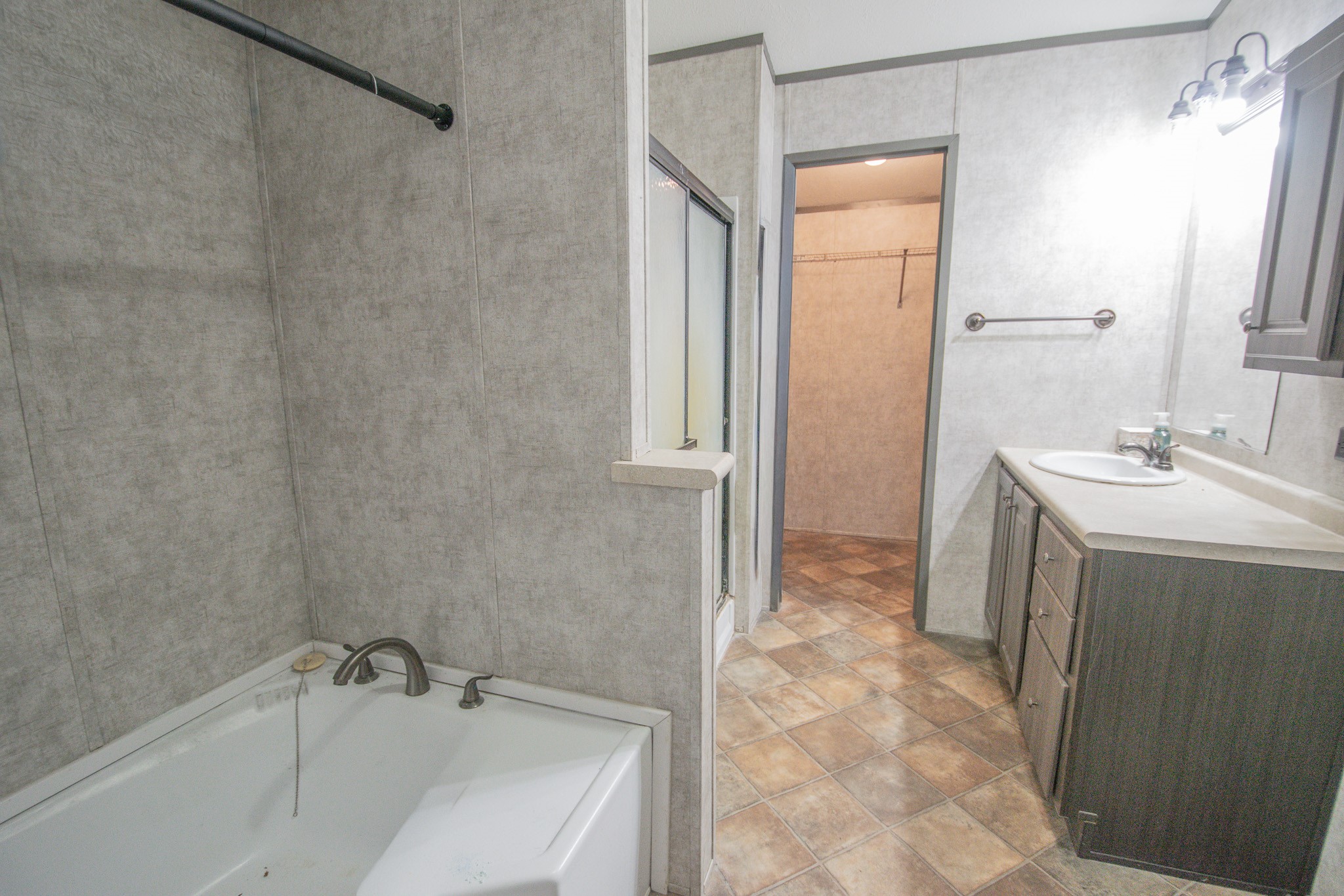 2801 County Road 444 Angleton, TX 77515 - Photo 16 of 38 a bathroom with a sink a mirror and a bathtub