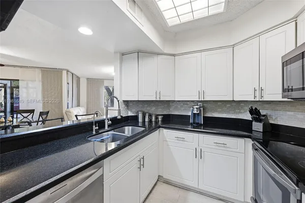 a kitchen with granite countertop a sink and cabinets