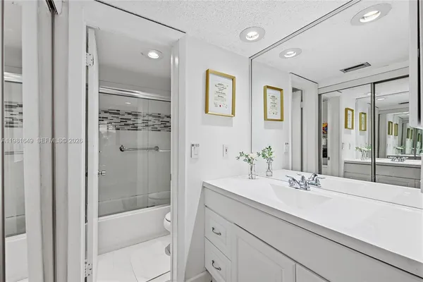 a bathroom with a shower sink and mirror