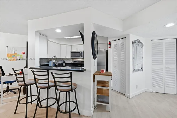 a kitchen with stainless steel appliances kitchen island granite countertop a refrigerator and microwave