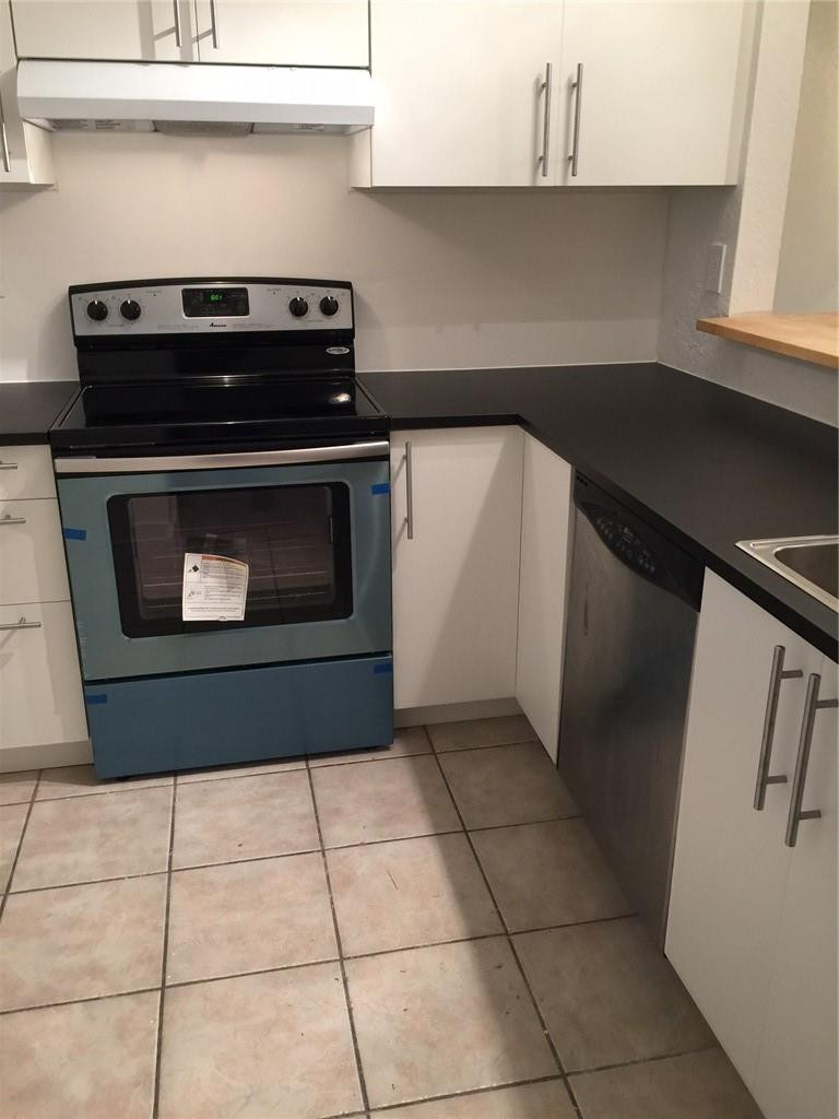 3470 Foxcroft Road, Unit 211 Miramar, FL 33025 - Photo 6 of 10 a kitchen with a stove and a microwave
