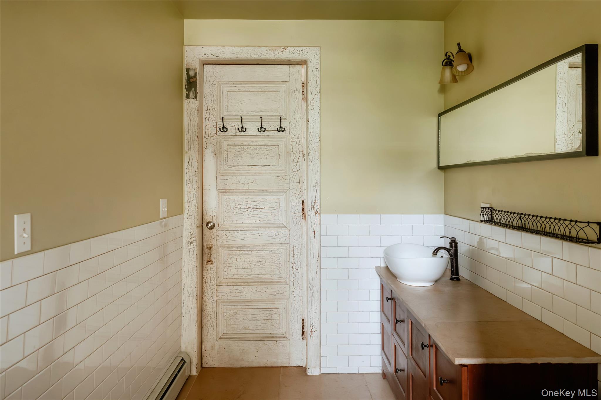48 Upper Main Street Callicoon, NY 12723 - Photo 31 of 48 Bathroom with tile walls, tile patterned flooring, vanity, a baseboard heating unit, and a wainscoted wall