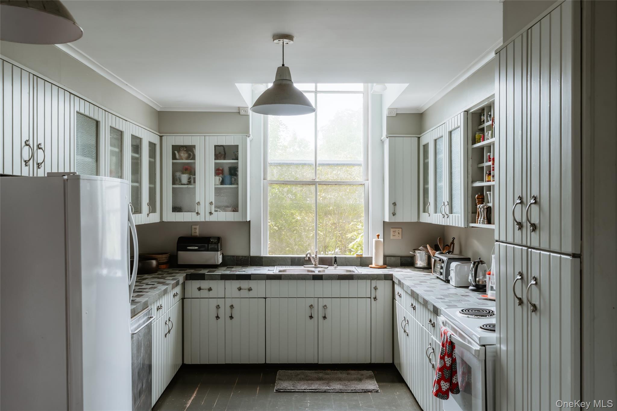 48 Upper Main Street Callicoon, NY 12723 - Photo 33 of 48 Kitchen with white appliances, white cabinets, crown molding, pendant lighting, and glass insert cabinets