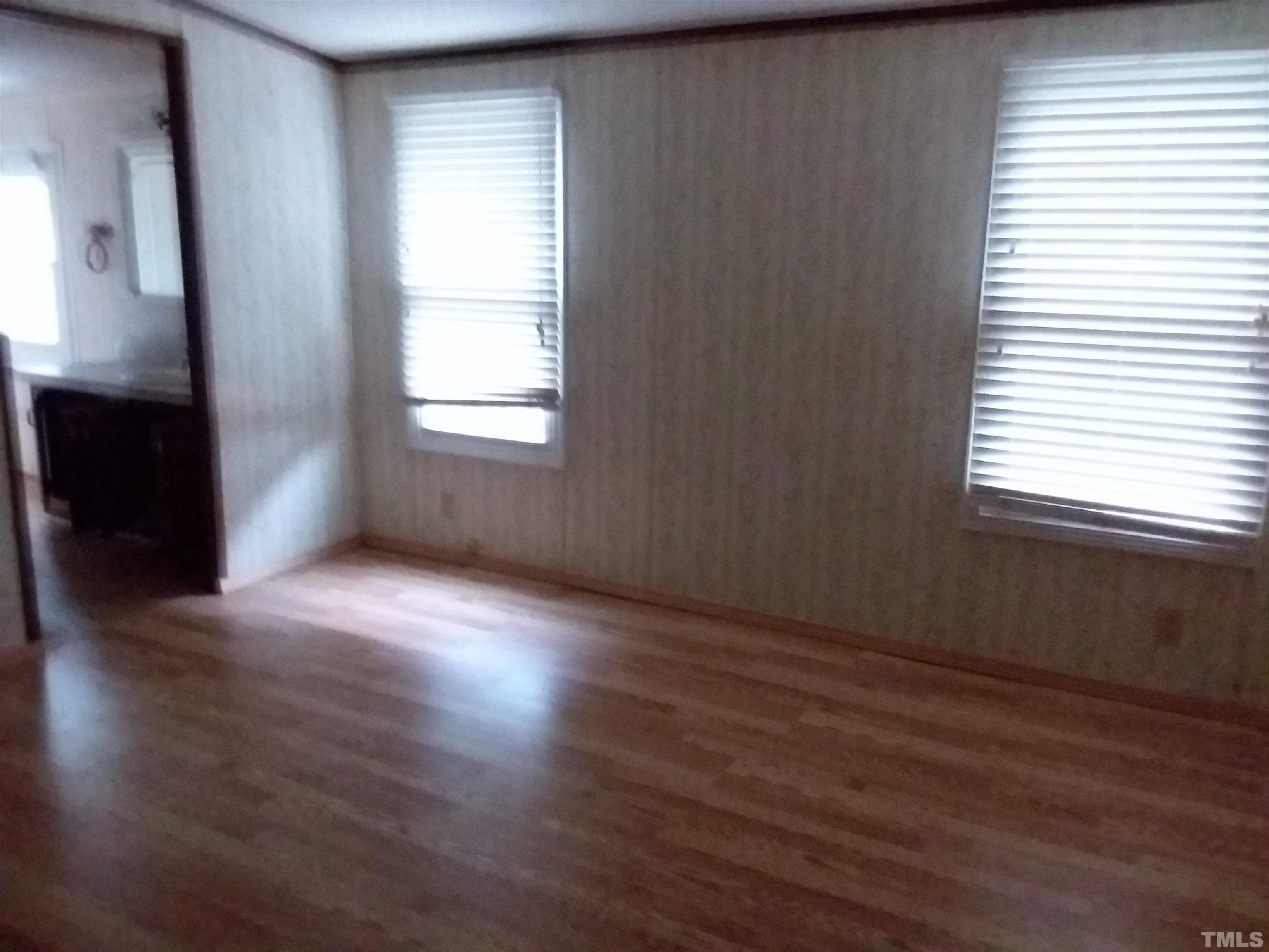 4644 Dusty Road Raleigh, NC 27610 - Photo 8 of 12 an empty room with wooden floor and windows