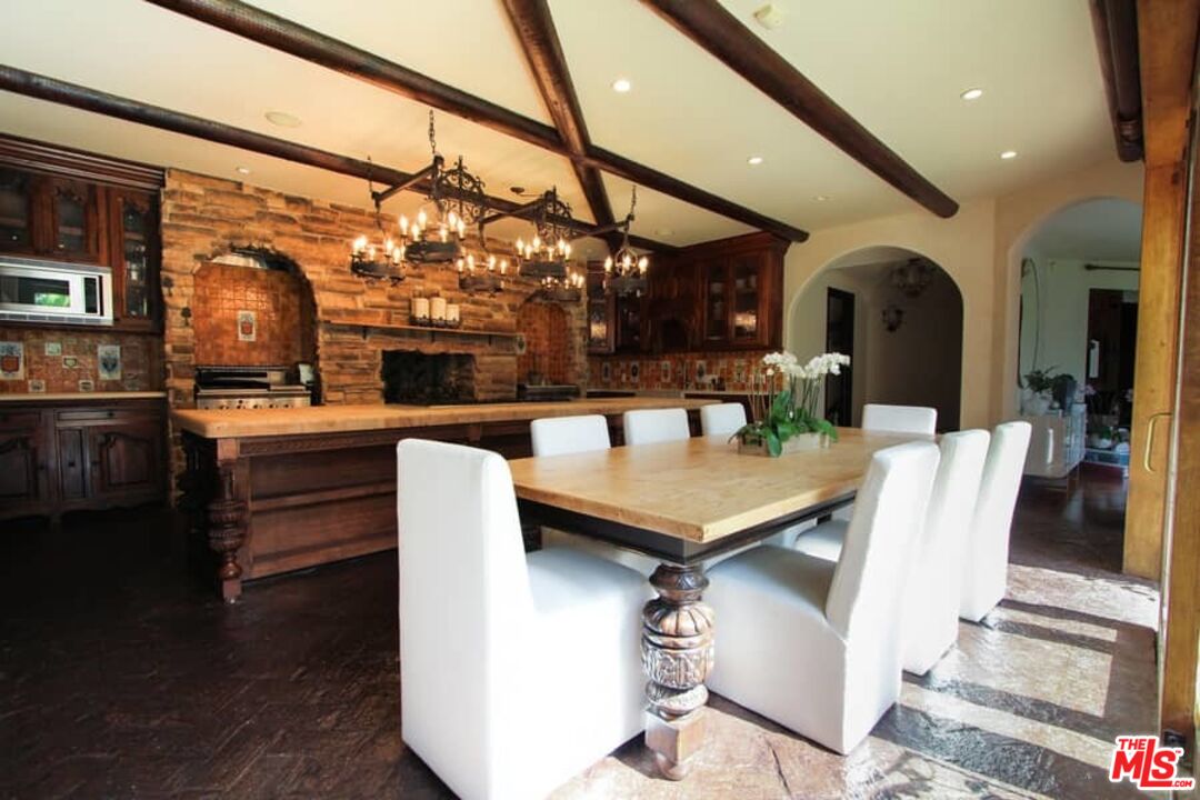 1016 Moraga Drive Los Angeles, CA 90049 - Photo 13 of 30 a dining hall with stainless steel appliances kitchen island granite countertop a table and chairs