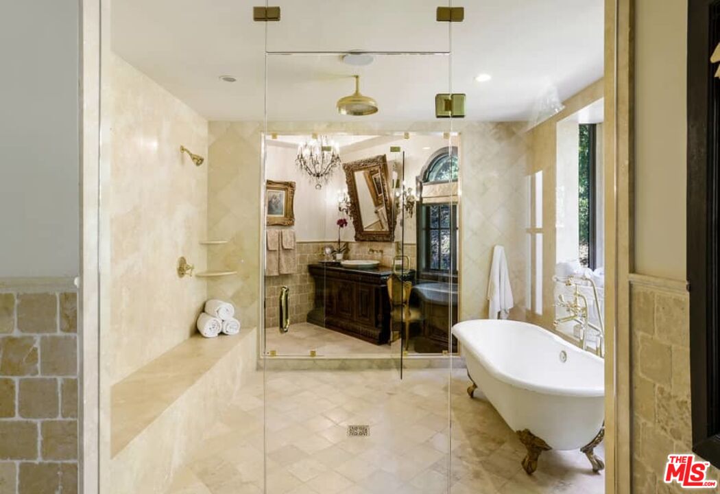 1016 Moraga Drive Los Angeles, CA 90049 - Photo 19 of 30 a bathroom with a sink and mirror with bathtub