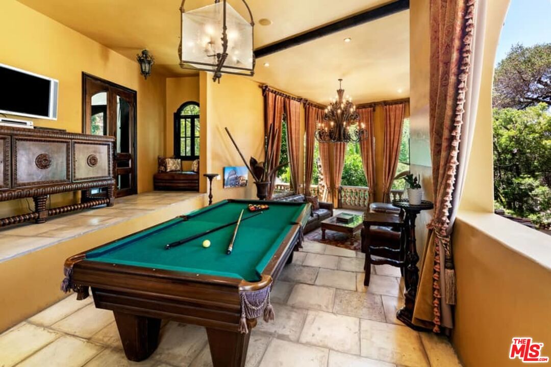 1016 Moraga Drive Los Angeles, CA 90049 - Photo 21 of 30 a yellow building with trees in front of it