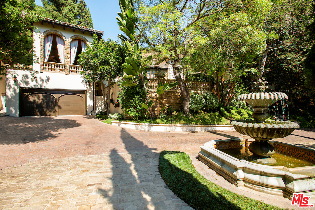 1016 Moraga Drive Los Angeles, CA 90049 - Photo 27 of 30 a white house with a yard and seating space