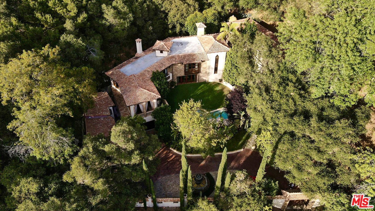 1016 Moraga Drive Los Angeles, CA 90049 - Photo 29 of 30 a view of a white house with a yard and sitting area